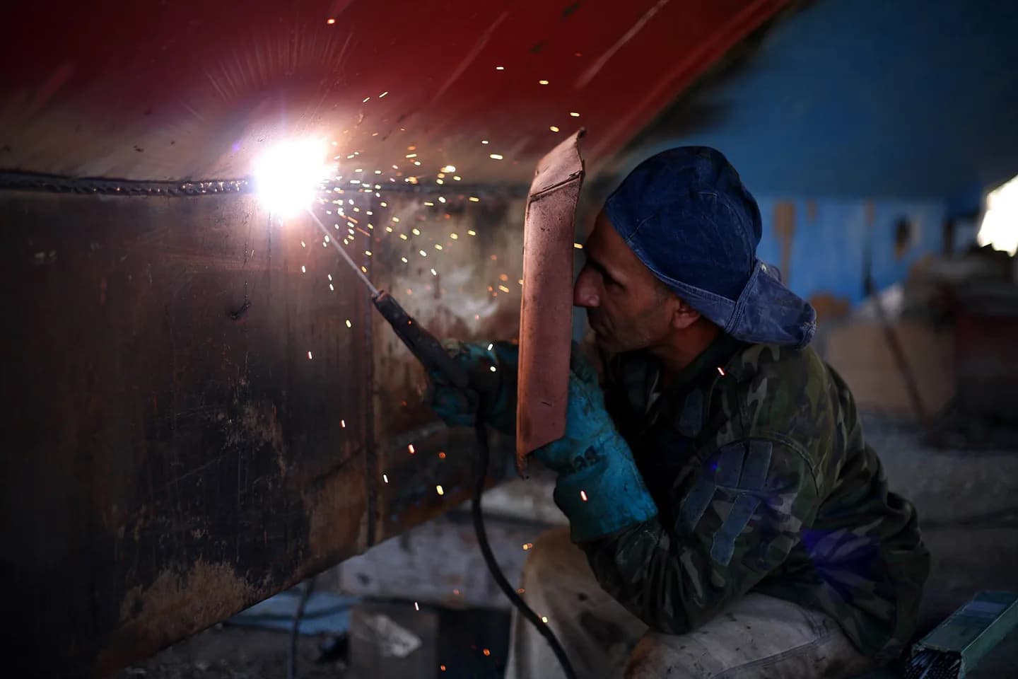 A welder working on steel in a fabrication workshop